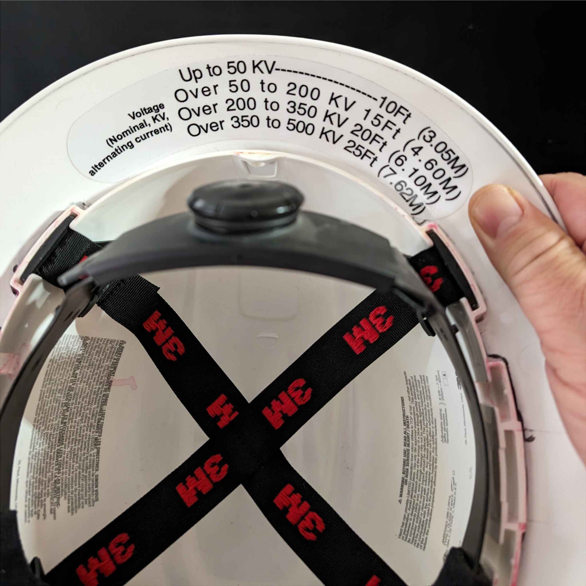 Power line clearance requirement chart printed on our under the brim hard hat decal. 