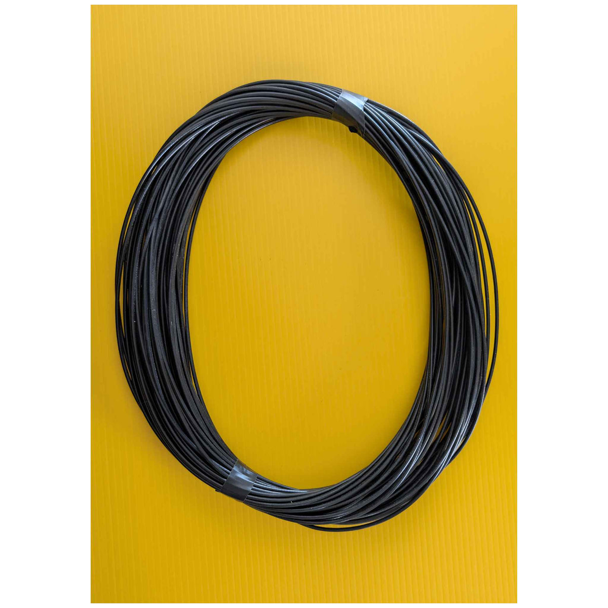 Coiled black A2B cable on a yellow background.