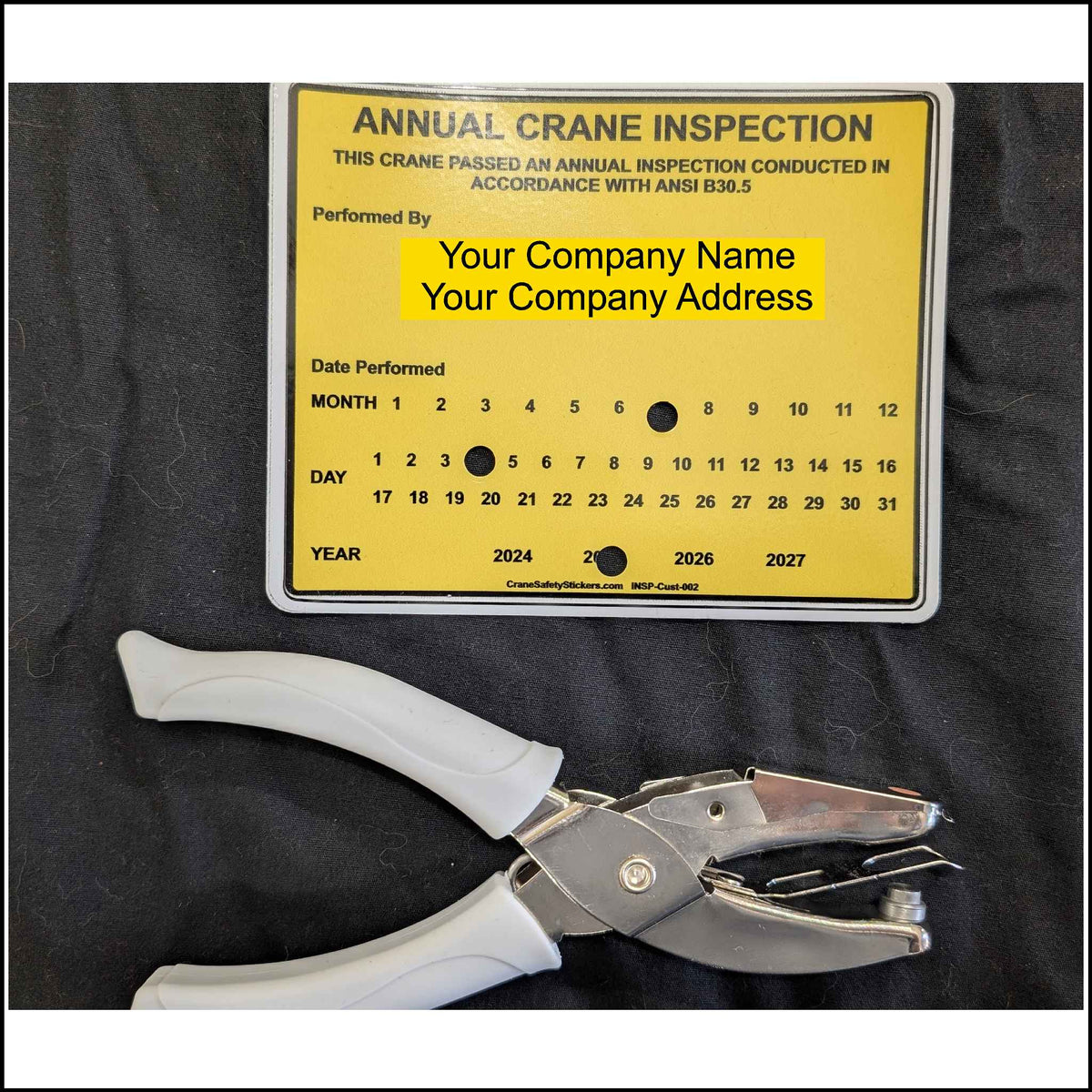 Long reach hole punch showing the holes on our annual crane inspection sticker.