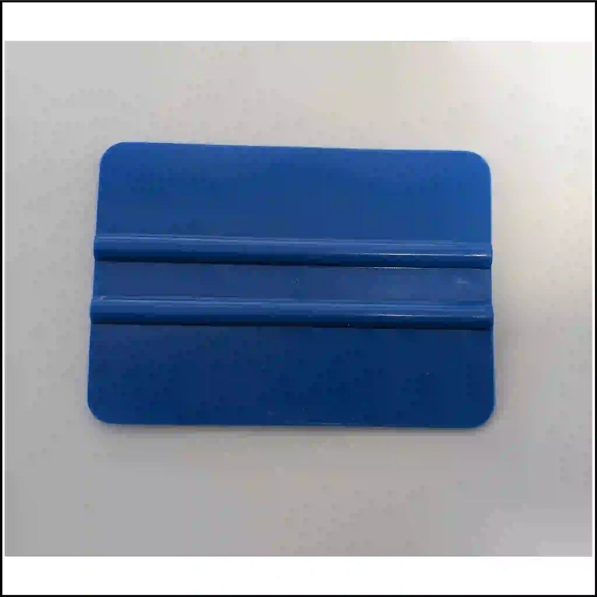 Blue vinyl decal application squeegee with rounded corners and two raised grip ribs.